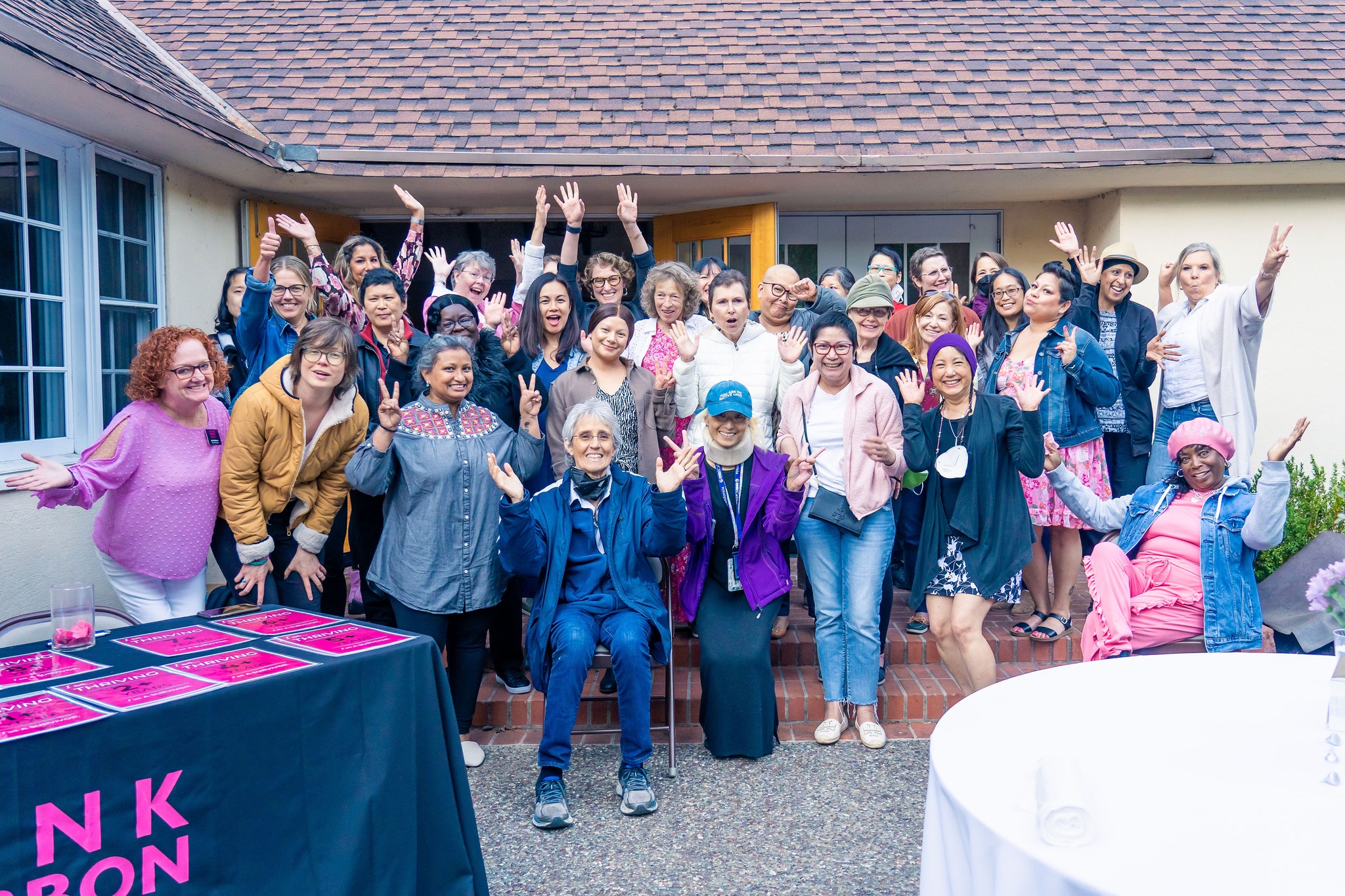 Group of women smiling with their hands in the air 